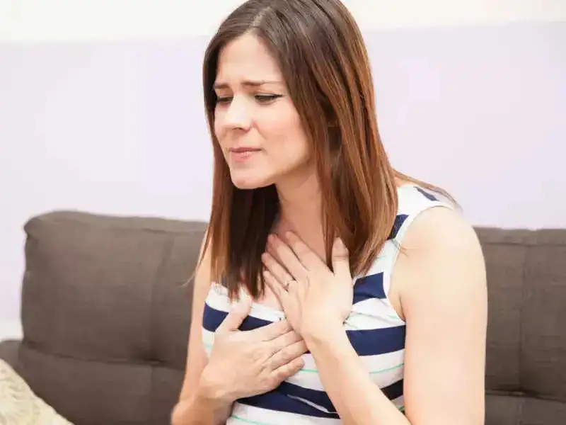 A woman experiencing heartburn